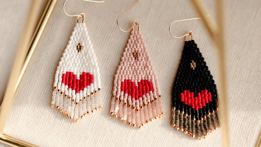 Three beaded heart-shaped earrings on a light background