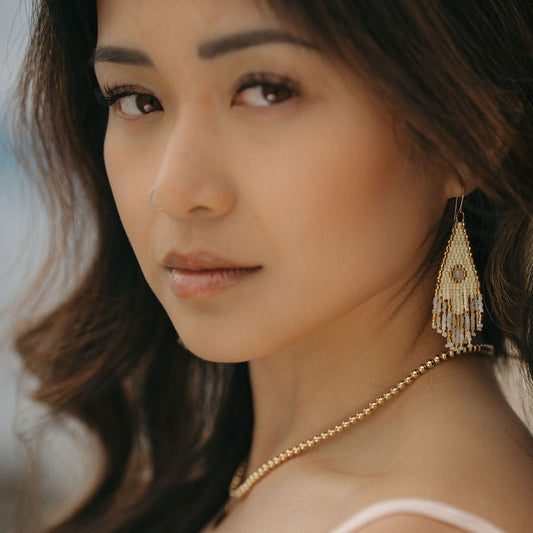 Close up of a woman's face wearing beaded earrings