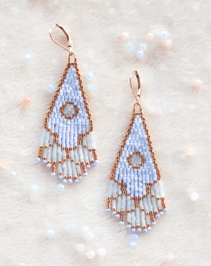 Handmade beaded earrings on a textured beige background