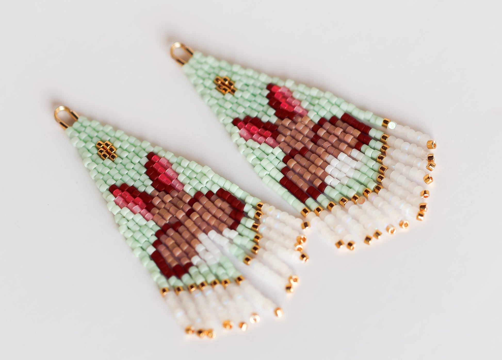 Handmade eaded earrings with bunny design on a light background