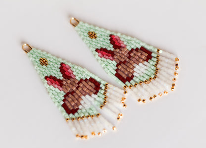 Handmade eaded earrings with bunny design on a light background