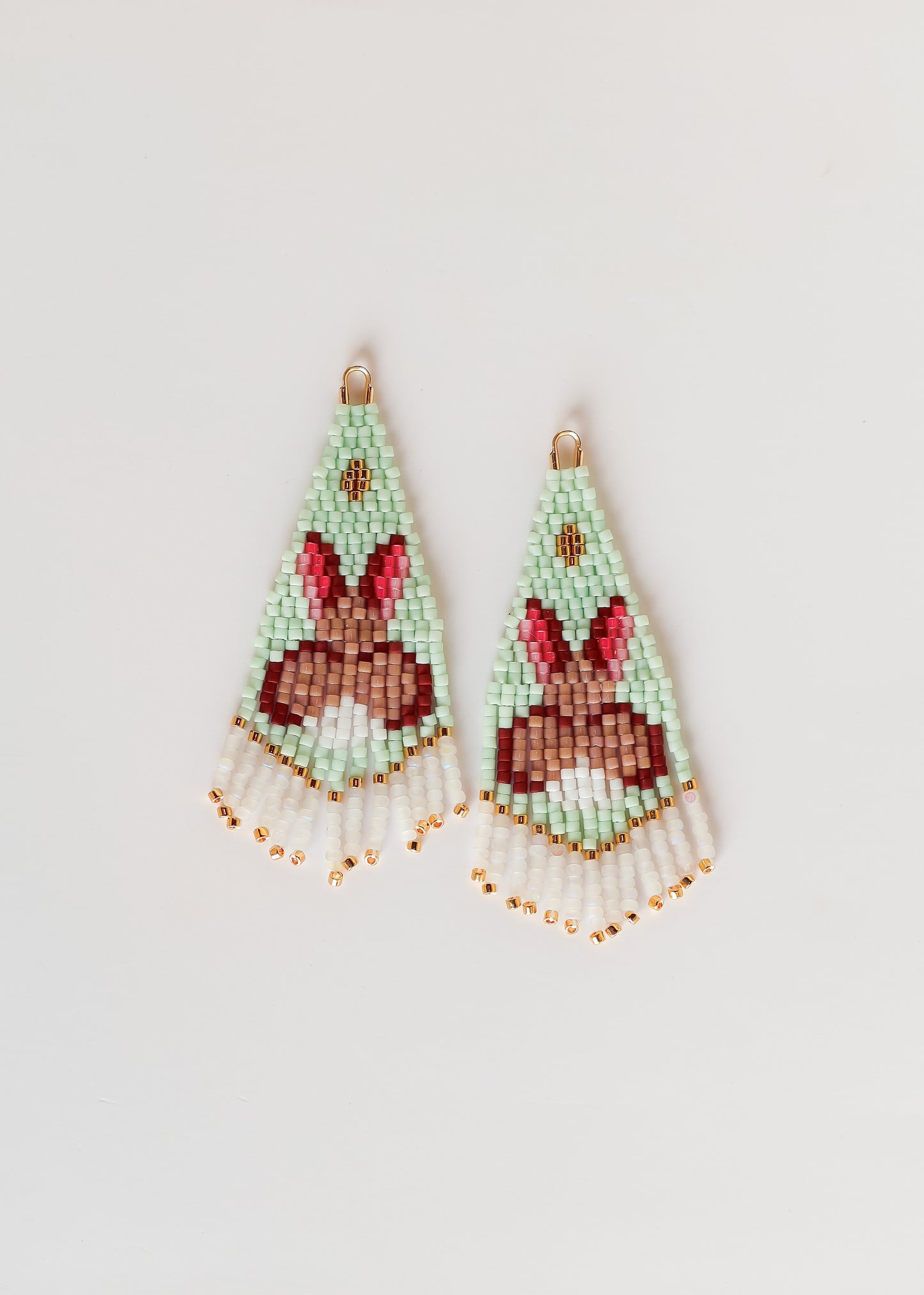 Beaded earrings with bunny design on a light gray background