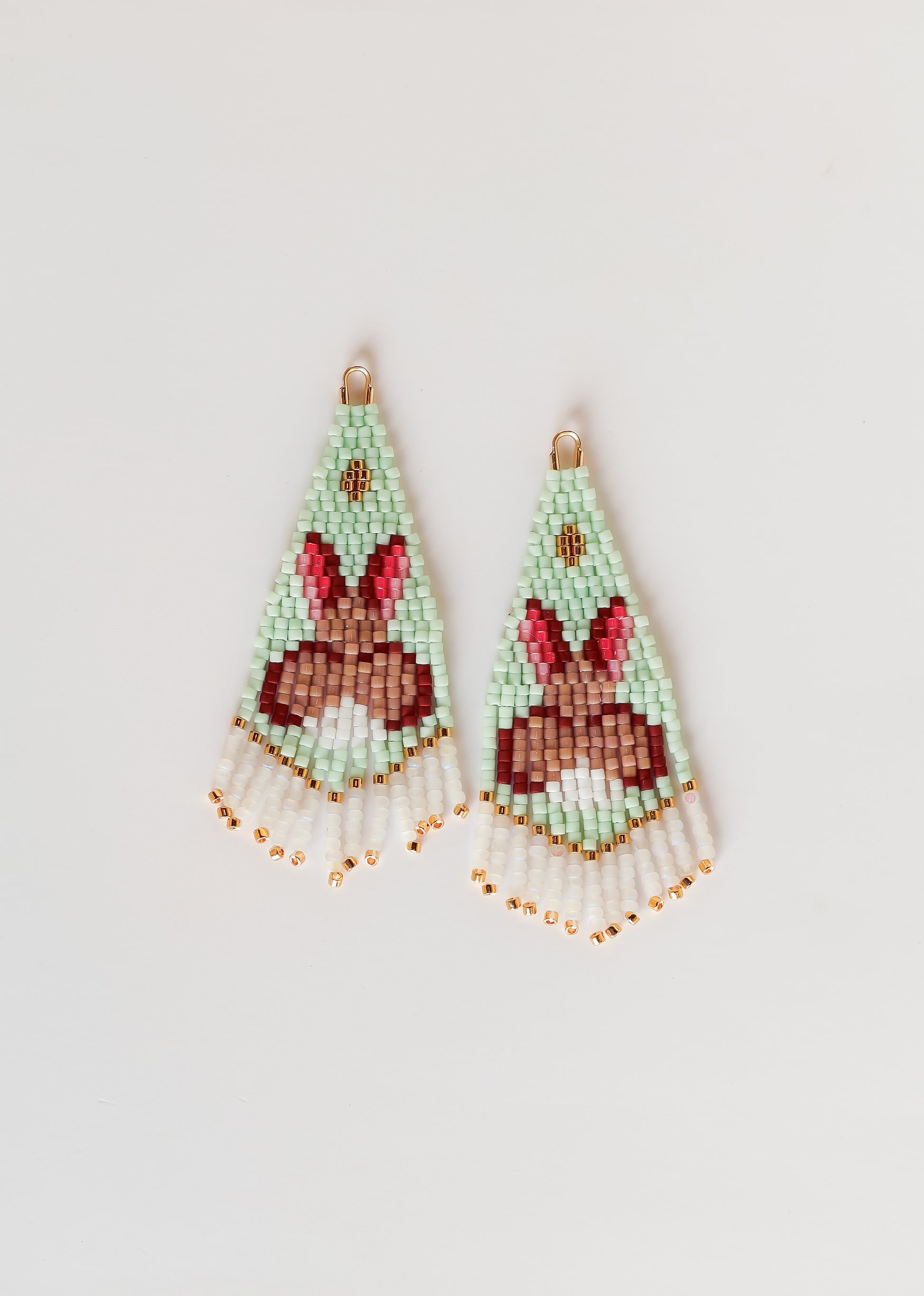 Beaded earrings with bunny design on a light gray background