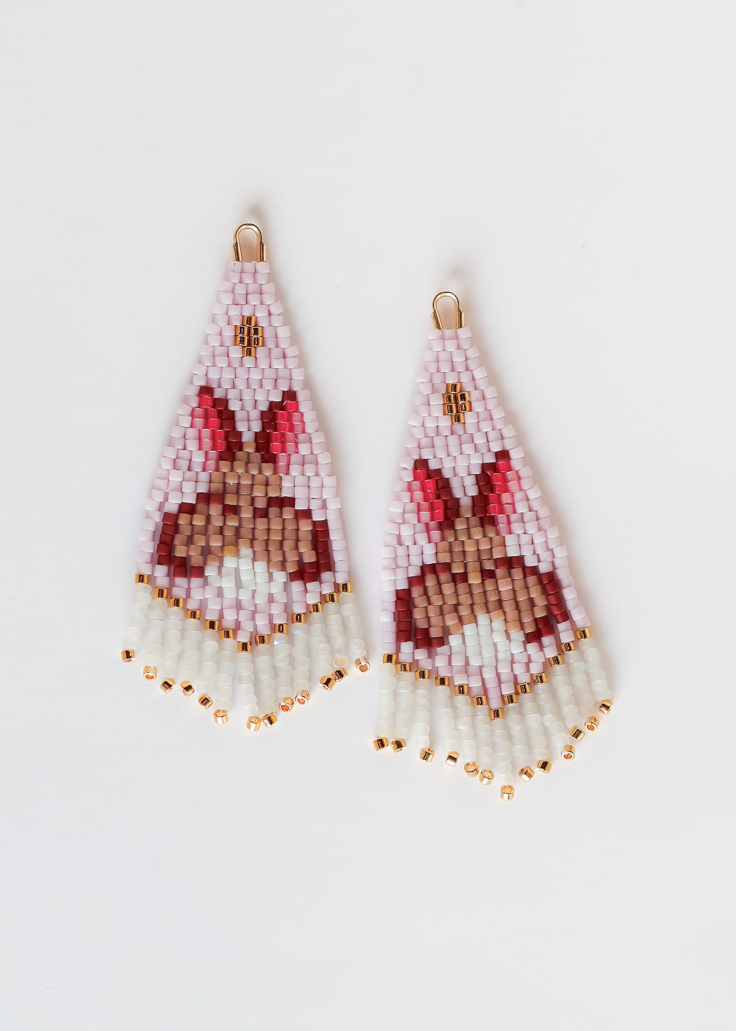 Pair of light pink beaded earrings with a bunny design on a white background