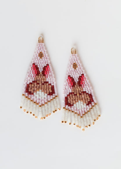 Pair of light pink beaded earrings with a bunny design on a white background