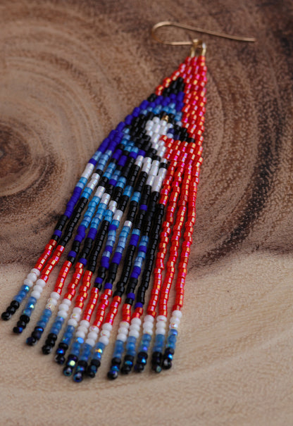 Beaded earrings with a bird design on a wooden surface