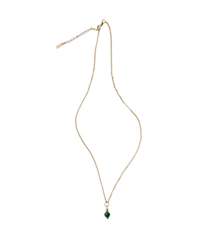 Gold necklace with a green pendant on a white background