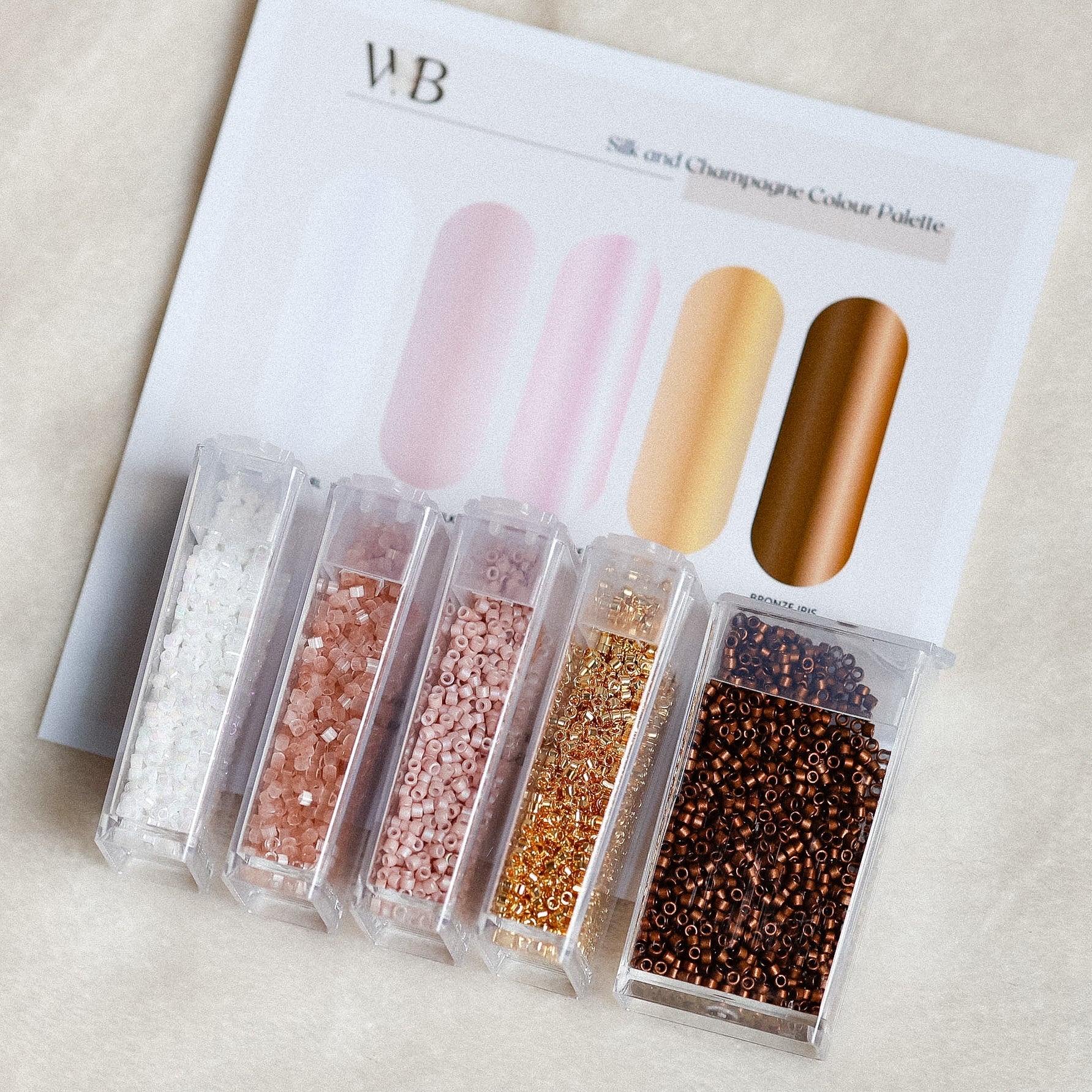 Set of bead samples with glittery finishes on a branded color palette.