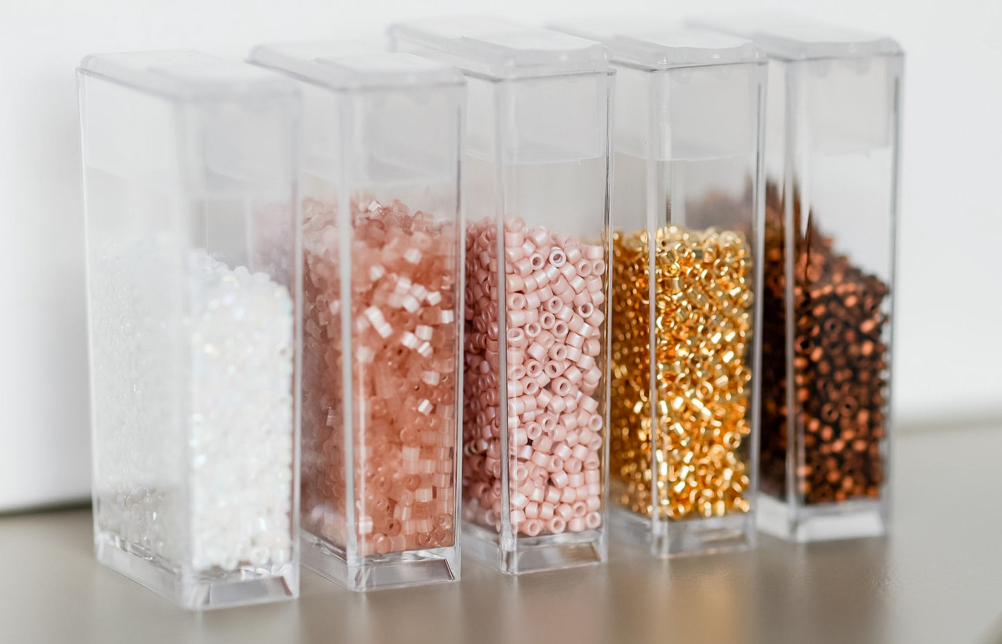 Clear containers with different colored beads on a light background