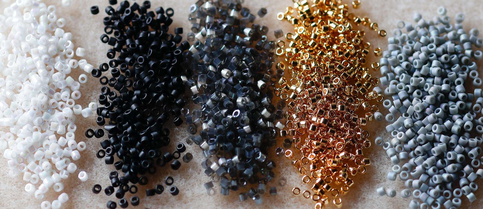 Collection of small beads in various colors on a textured surface