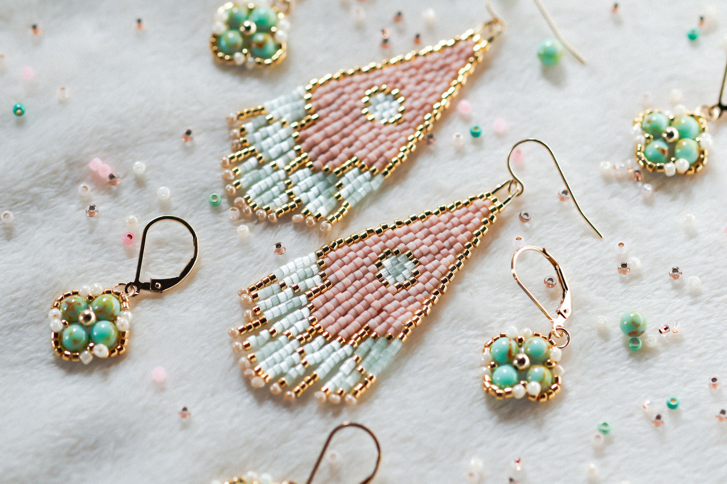 Colorful handmade beaded earrings on a textured surface