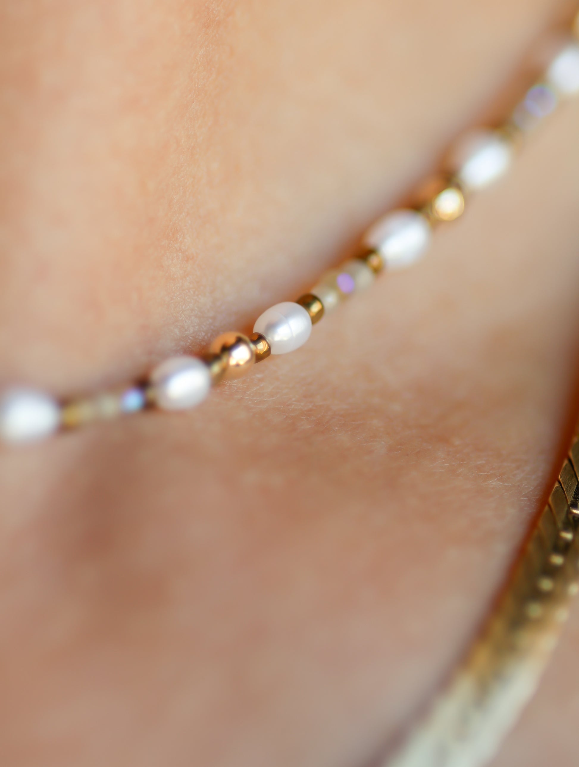 Close up of a white and gold beaded bracelet 