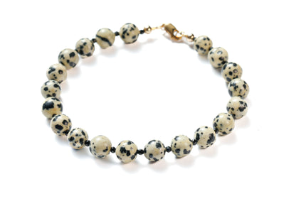 Bracelet with dalmatian jasper beads on a white background