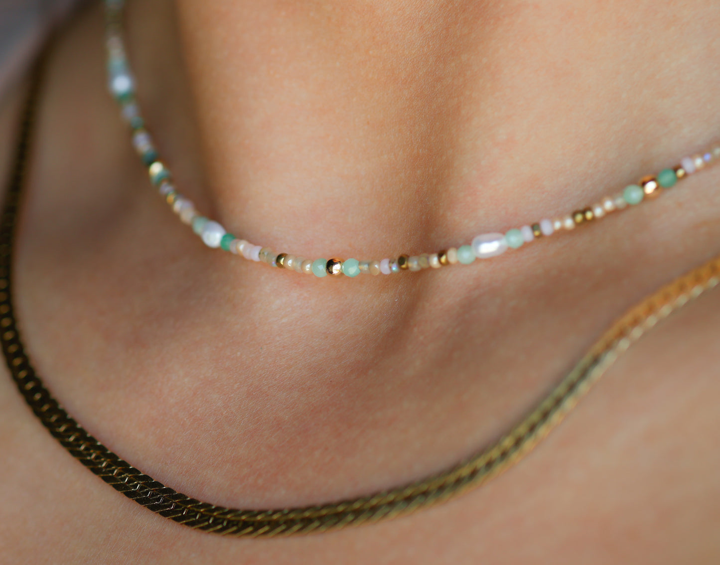 Close-up of a necklace with small beads on a person's neck