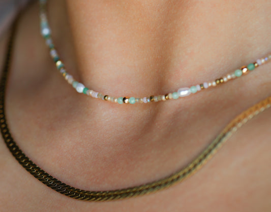 Close-up of a necklace with small beads on a person's neck
